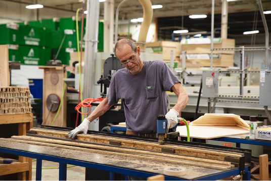 Team member using tools to craft products.