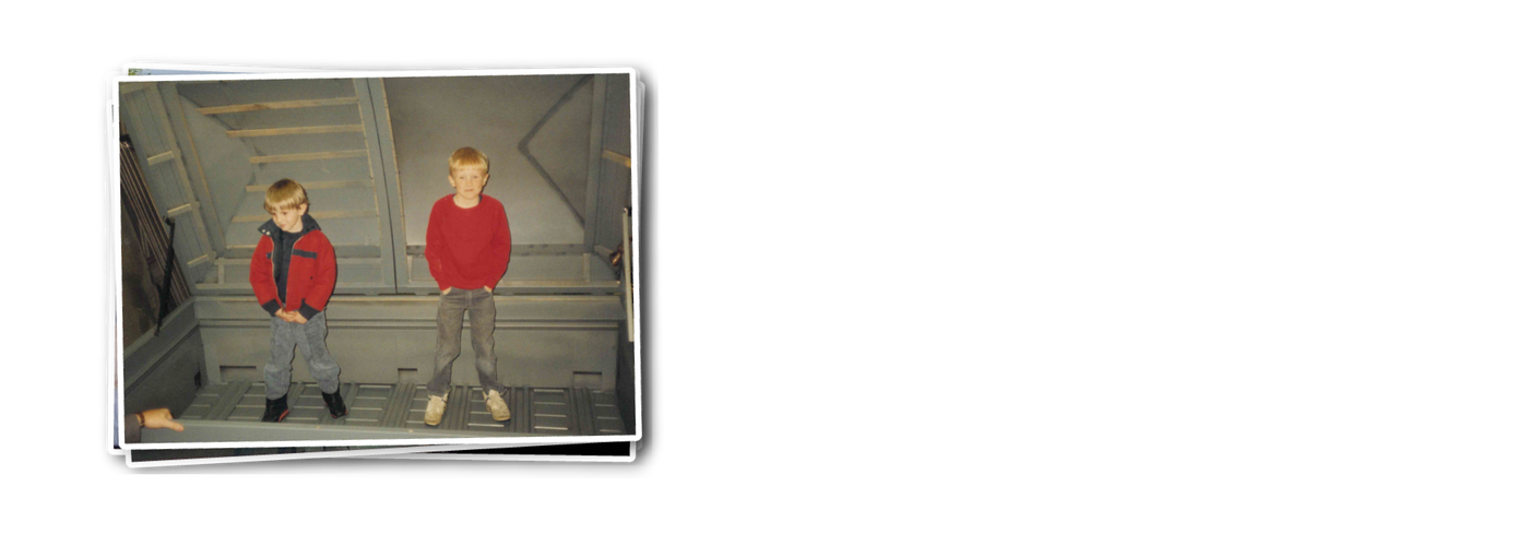 Vintage photo of Justin and Bryan Davis as young children standing inside an oversized metal casket frame