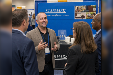 Michael Jewart at a conference speaking to Funeral Professionals in front of the Starmark booth.