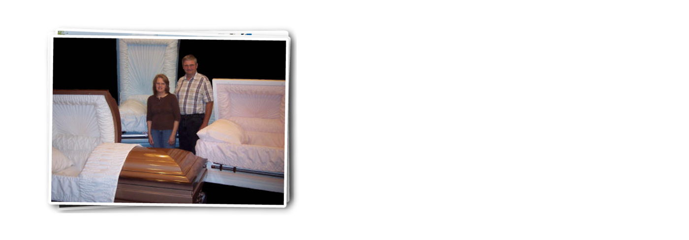 Keith Davis and Wife standing among three oversized caskets